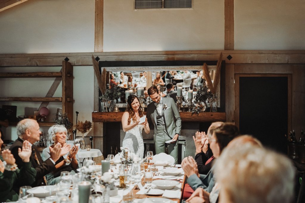 Braut und Bräutigam halten emotionale Rede bei Scheunenhochzeit in Baden-Württemberg.